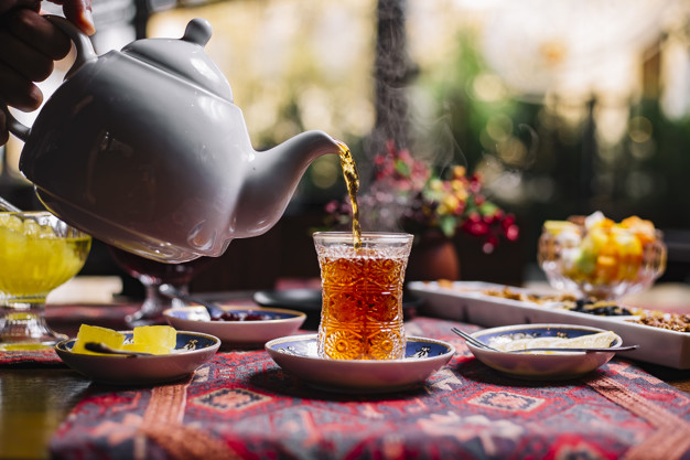 man pouring tea in armudy jam lemon side view